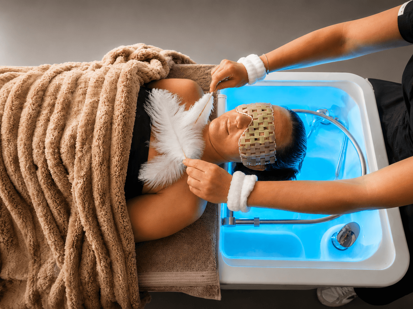 Guest receiving a Cloud 9 Total Bliss head spa with illuminated basin and feather ritual